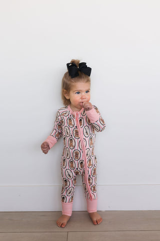 In My Jammers Howl-O-Ween Pups Zipper Romper Child wearing a patterned onesie with pink accents against a white background