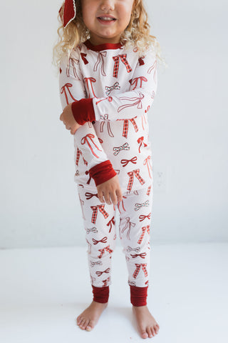 In My Jammers Merry Little Bows Two Piece Set
Child wearing a white onesie with red patterns on a plain background