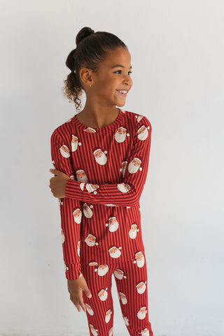 In My Jammers Santa Two Piece Set
Child wearing a red pajama set with Santa Claus pattern on a white background