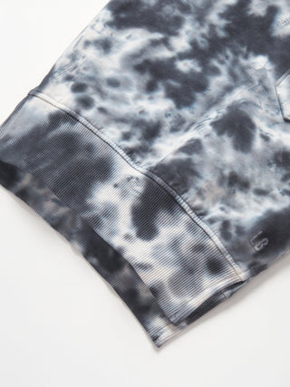 Little Bipsy Marble Pullover - Blue
Close-up of a tie-dye pattern on a fabric with a brand logo.