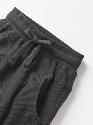 Little Bipsy Waffle Jogger - Shadow
Dark gray waffle knit shorts with drawstring on a white background