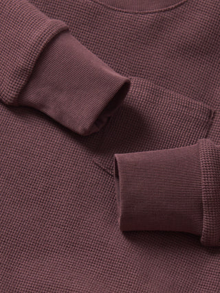 Little Bipsy Waffle Top - Huckleberry
Close-up of a brown textured sweater with rolled-up sleeves.