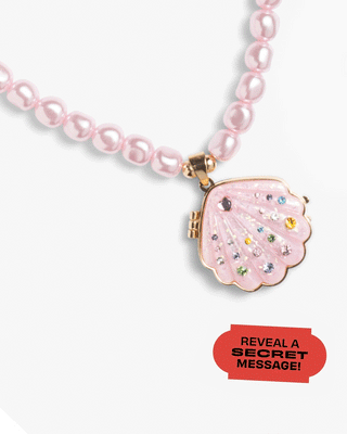 Super Smalls Sparkle Shell Lipgloss Locket necklace with a shimmering shell-shaped pendant and a clear display window.