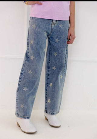 Lola and The Boys Crystal Stars Jeans Person wearing blue jeans with star patterns and white boots on a white background
