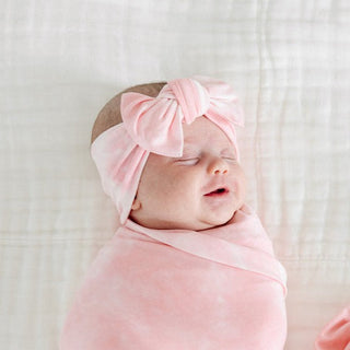 Lou Lou and Company Headband - Emily
Newborn baby wrapped in pink fabric with a matching headband on a light background