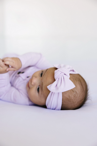 Lou Lou and Company Headband - Isabelle
Baby wearing a purple outfit and headband on a white background