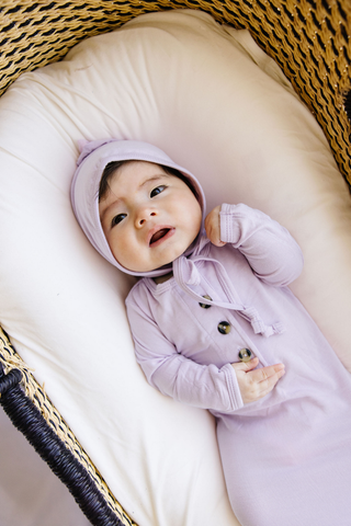 Lou Lou and Company Knotted Gown - Isabelle
Baby in a purple outfit lying on a white cushion inside a wicker basket