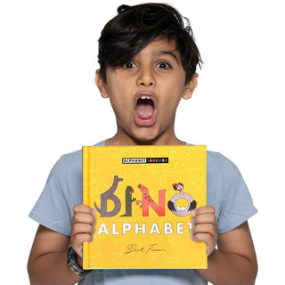 Dino Alphabet Hardcover Book
Child holding a yellow book titled 'Dino Alphabet' with a surprised expression on a white background