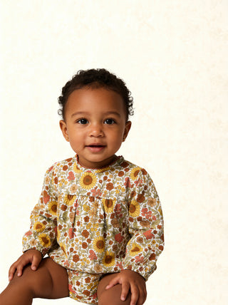 Alto Modas Maeve baby bubble dress with sunflower print, lightweight fabric, and ruffled sleeves, perfect for warm weather.