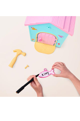 Little Live Pets™ Kitty’s Home Minis with Buildable House
Person writing 'Kitty' on a pink object with a pen, surrounded by toy accessories on a light background.