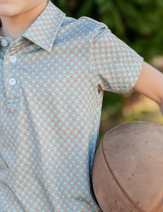 Properly Tied Boys Inlet Polo shirt in navy with white collar and logo, laid flat to show front view.