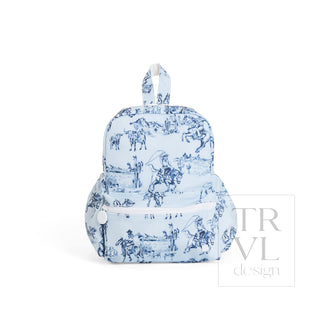 TRVL Designs Mini Backer - Cowboy Toile
A small light blue backpack with a dark blue toile de Jouy print depicting cowboys and horses, featuring a front zippered pocket and a top carry handle, shown on a white background with a 'TRAVEL design' watermark.