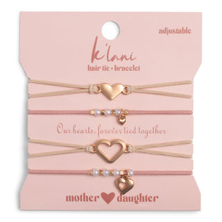 K'lani "Mother / Daughter" Pink with Pearls and Gold Hearts Shareable Hair Tie Bracelets
Set of hair ties and bracelets with heart-shaped charms on a pink card, featuring the brand 'K'lanii'.