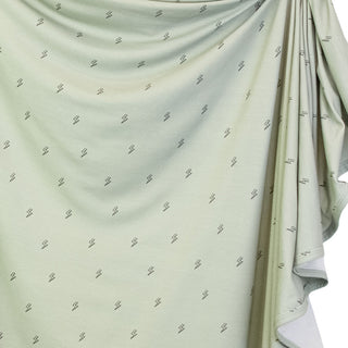 Lou Lou and Company Knit Swaddle Blanket - Nash
Light green fabric with small patterns draped over a white surface