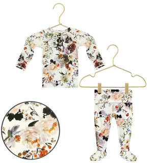 Lou Lou and Company Top and Bottoms - Nellie
A baby clothing set consisting of a long-sleeve top and footed pants, both featuring a watercolor floral print on an off-white background. The top is shown on a gold hanger, the pants on a hanger with clips, and a circular zoom-in detail of the floral pattern is shown in the bottom left corner.