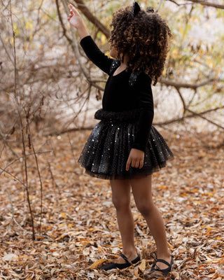 Noralee Lottie Tutu Set - Night Sky
Child in a black dress with sequin skirt standing in a forest setting