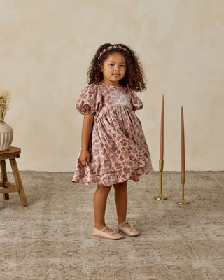Noralee Luna Dress - Harvest Fleur
Young girl in a floral dress standing in a room with a wooden stool and candles.