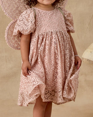 Noralee Luna Dress - Rose Embroidered Daisy
Child wearing a pink floral dress with butterfly wings against a beige background