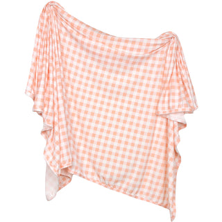 Lou Lou and Company Evie swaddle blanket in peach gingham, soft cotton fabric with a charming checkered pattern.