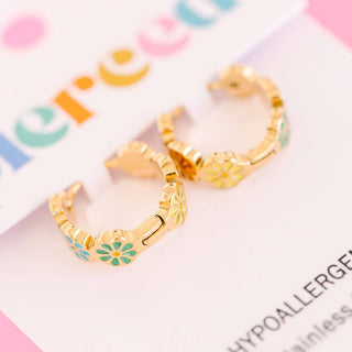Pierced Co. Colorful Daisy Huggies
Gold hoop earrings with green accents on a colorful background
