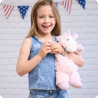 Pink Unicorn Warmies
Young girl holding a pink plush unicorn toy with a decorative flag background