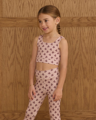 Play by Rylee & Cru Swift Sports Bra - Blush Fleur Play by Rylee & Cru Basic Legging - Blush Fleur Young girl wearing a pink floral outfit against a wooden background