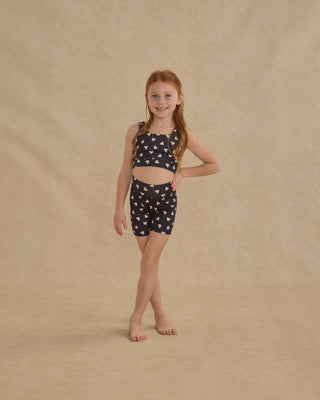 Play by Rylee & Cru Swift Sports Bra - Hearts
Young girl wearing a black and white patterned outfit on a beige background