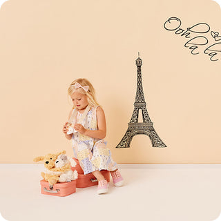 Warmies Puppy Hugs
Young girl playing with toys in front of a wall with an Eiffel Tower design and 'Ooh La La' text.