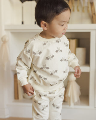 Quincy Mae Relaxed Fleece Sweatshirt & Relaxed Sweatpant Set - Bats
Child wearing a white outfit with gray animal prints in a home setting