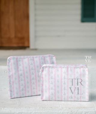 TRVL Designs Roadie Medium Zip Pouch - Ribbon Floral Pink
Two pink and white striped pouches with 'TRVL' branding on a light surface.