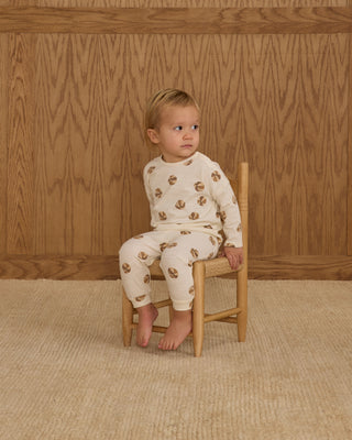 Rylee & Cru Long Sleeve Tee + Pant Set - Basketball
Child wearing a white outfit with brown patterns sitting on a wooden chair against a wooden paneled wall.