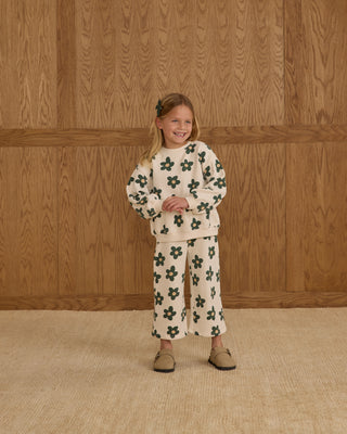 Rylee & Cru Oversized Sweatshirt & Wide Leg Sweatpant Set - Daisy
Young girl wearing a floral outfit standing against a wooden paneled wall.