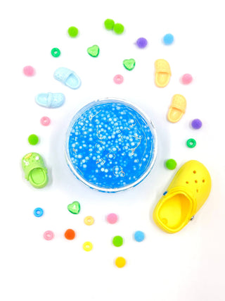 Bright green slime titled "You Croc My World" from Young Wild and Friedman, with a playful, glossy texture and vibrant color.