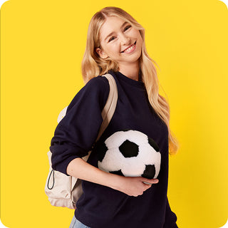 Soccer Ball Warmies
Woman wearing a navy sweater with a soccer ball design against a yellow background