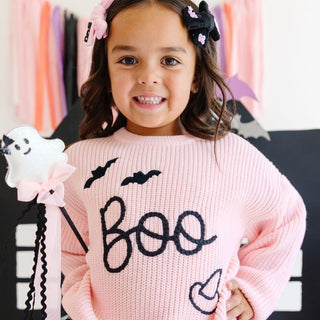 Sweet Wink Boo Bows Halloween Clip Set 
Child wearing a pink sweater with 'boo' and Halloween graphics, holding a ghost toy.