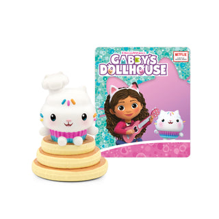 Tonies Character - Dreamworks: Gabby's Dollhouse: Cakey Cat 
Toy figure of a white cat with rainbow hair on a stack of rings next to a 'Gabby's Dollhouse' book